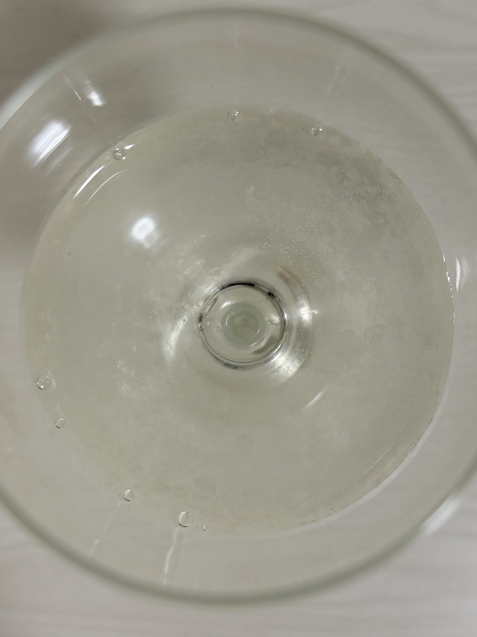 Overhead view of the sake in a wine glass, showing clarity despite being unfiltered