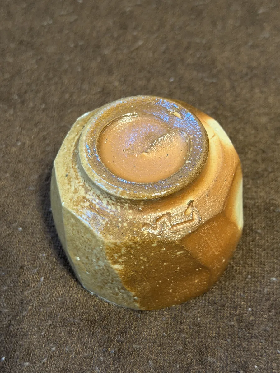 The underside of the Bizen guinomi, showing the foot and a small stamped mark