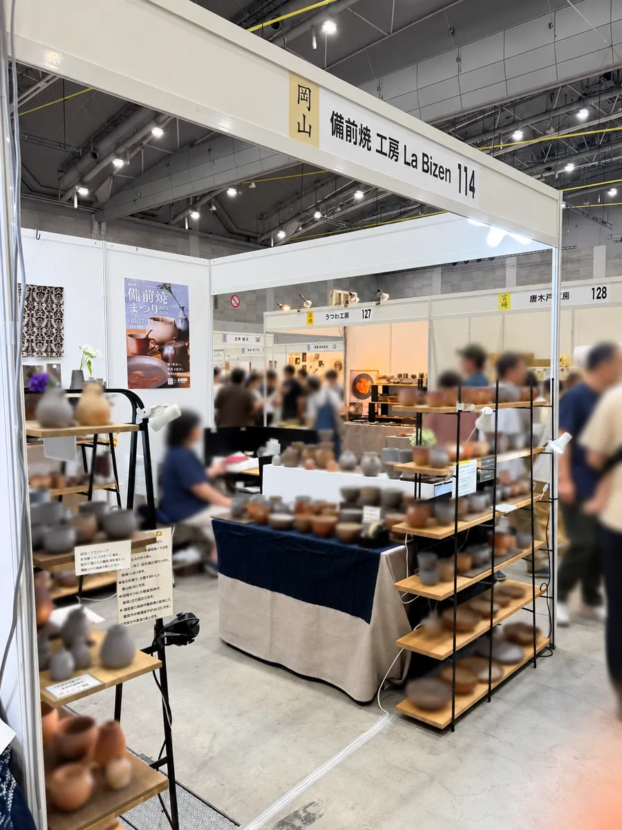 The La Bizen booth at the pottery fair in Kokura, with shelves of Bizen ware
