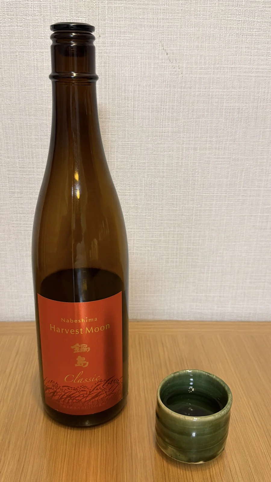 Nabeshima Harvest Moon with an Oribe ware guinomi, its green glaze against the orange label