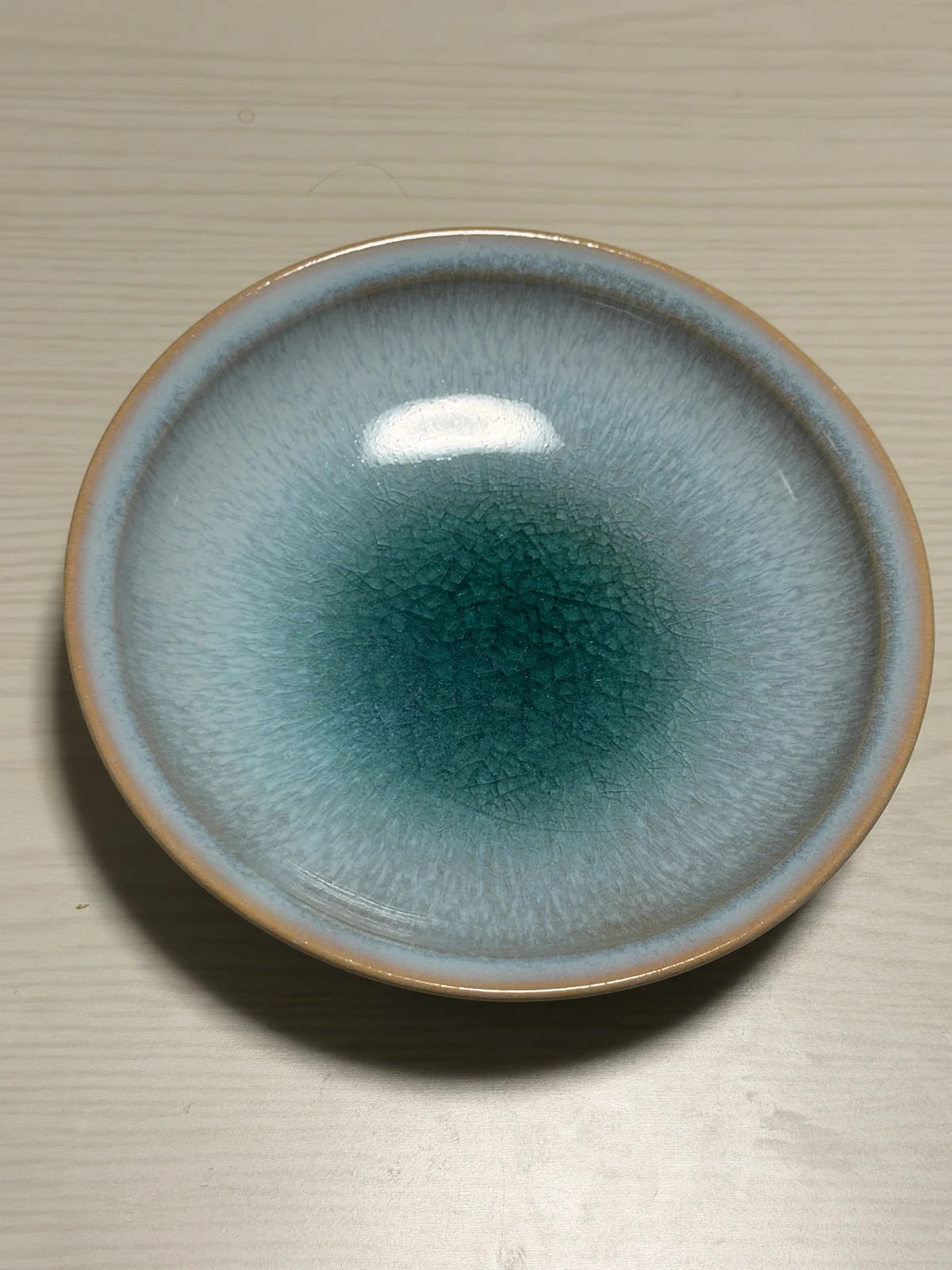 Empty Hagi ware plate by Tenryu Kiln viewed from above, pale blue with a deep turquoise center and a beige rim